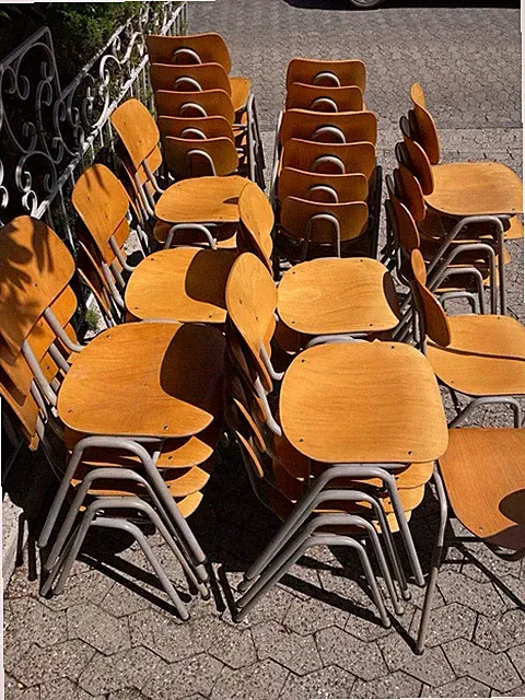 36 stabile Stapelstühle mit Holzsitz und Holzrückenlehne.