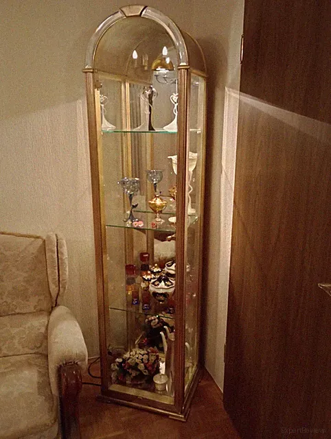 Glasvitrine mit goldfarbenem Korpus , Beleuchtung , und Spiegelrückwand